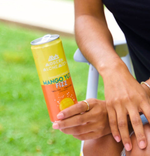 Person holding Mango Yuzu Fizz Modern Alchemist Cannabis Infused Mocktail. Alcohol free.