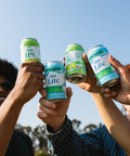Four cans of 'THC Lite' and 'THC IPA' being held up against a clear blue sky.