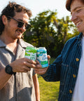 Two people holding cans of Float House in a field