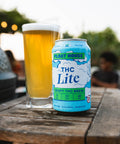 Can of THC Lite brew on a wooden table with a blurred outdoor background