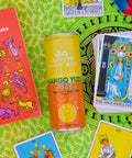 Mango Yuzu Fizz Modern Alchemist Cannabis Infused Mocktail on a towel by the pool with tarot cards surrounding the can. Alcohol free. 