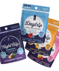 Sample pack showing a stack of 4-pack packaging renders of all four flavors of gummies: Night Trip CBD + CBN-infused blackberry lemon, Daytrip blueberry hibiscus CBD-infused, Daytrip apricot vanilla CBD-infused, and Daytrip strawberry lemonade CBD-infused