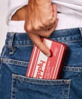 Person holding a red and white Happly socialize package in their jeans pocket.
