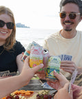 People smiling and holding Variety Pack of Modern Alchemist Cannabis Infused Mocktails including Citrus Spritz, Jungle Bird, and Margarita. Alcohol free.
