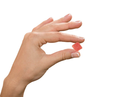 hand holding sour strawberry euphoria gummy on white background